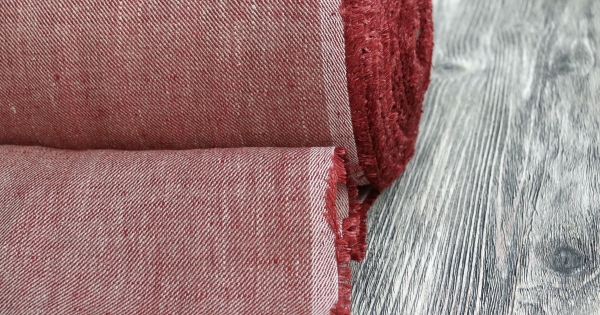 красные нитки на льняной ткани крупным планом